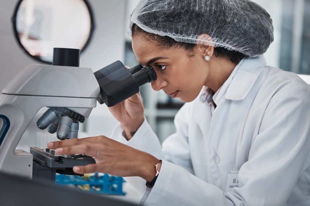 Scientist, black woman and microscope, analysis of data and science innovation, microbiology or bio